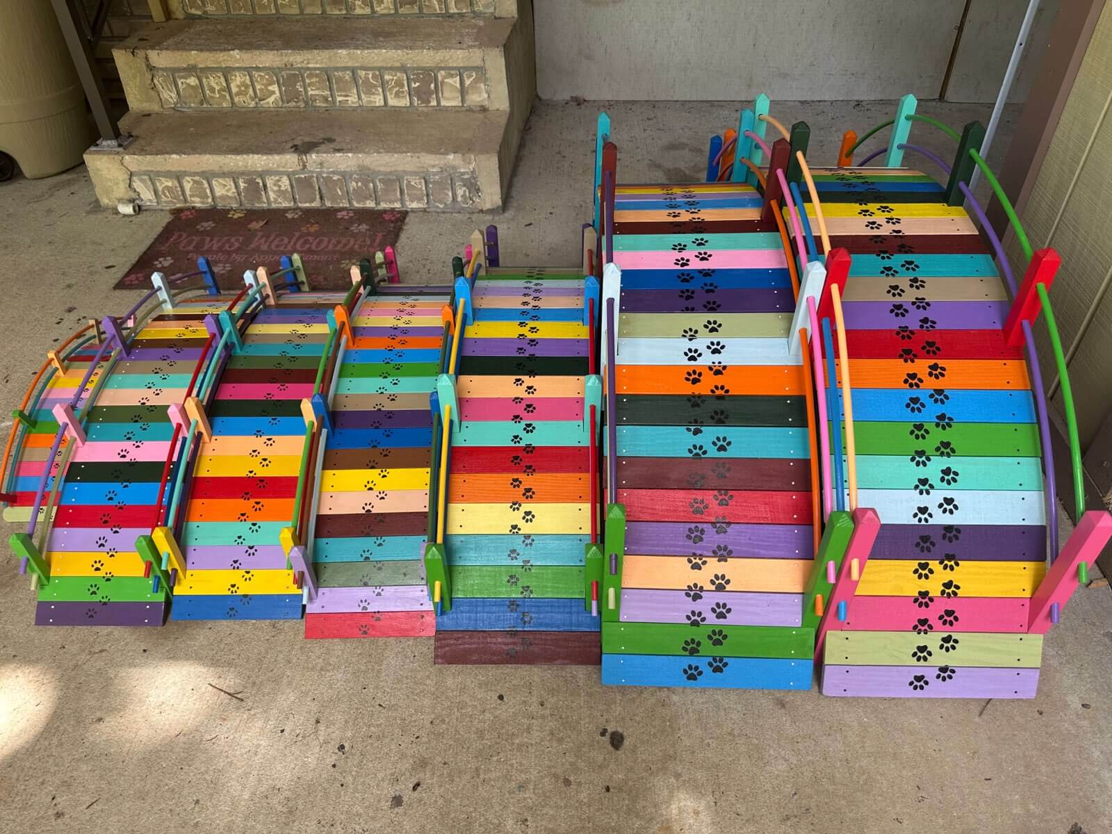 Dozens of Paul's handcrafted rainbow bridges, overhead view, every one unique with paw print details