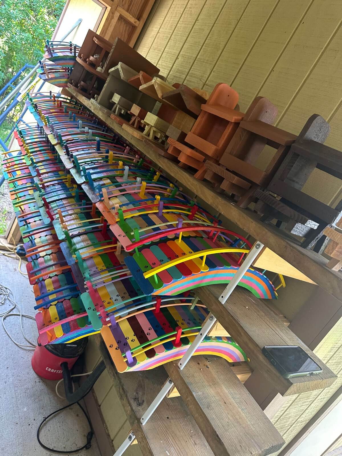 Row of rainbow bridges along Paul's workshop shelf with squirrel feeders above