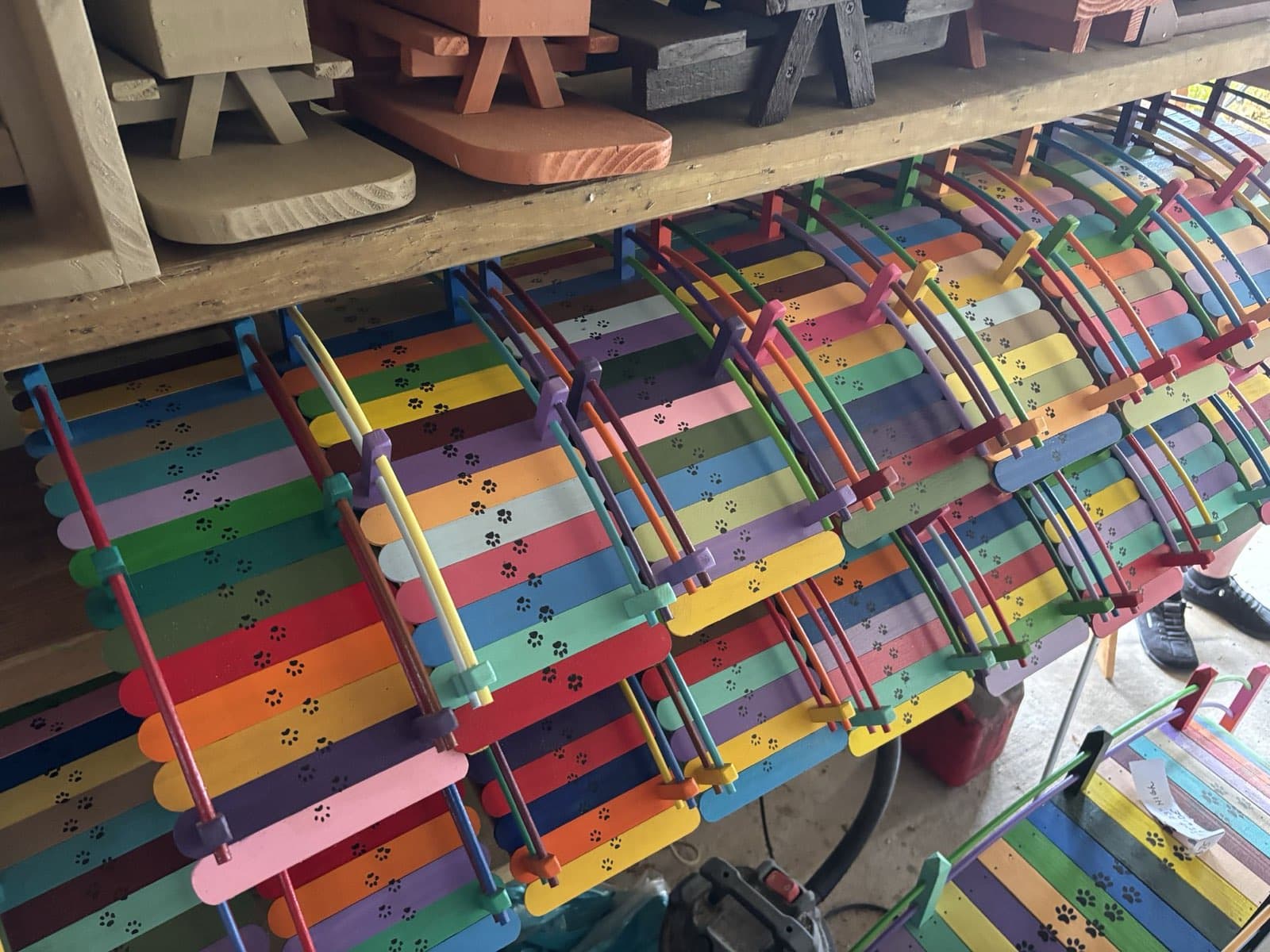 Rows of Paul Allabaugh's finished small Rainbow Bridges on the workshop rack, ready to find new homes