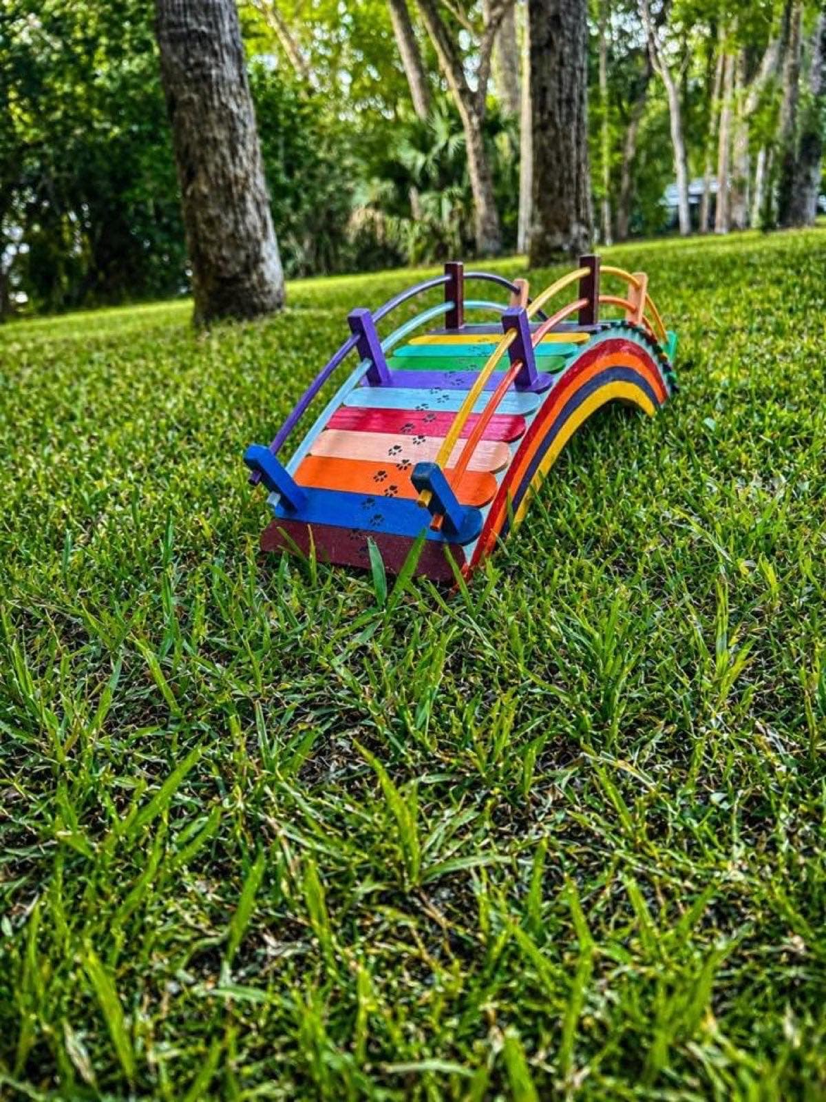 One of Paul Allabaugh's Rainbow Bridges placed on the grass under the trees, memorial-ready